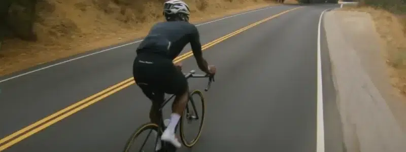 A cyclist holding their ear and head in pain on a ride