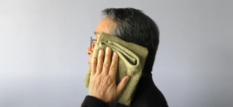 Applying a warm compress to a sore neck