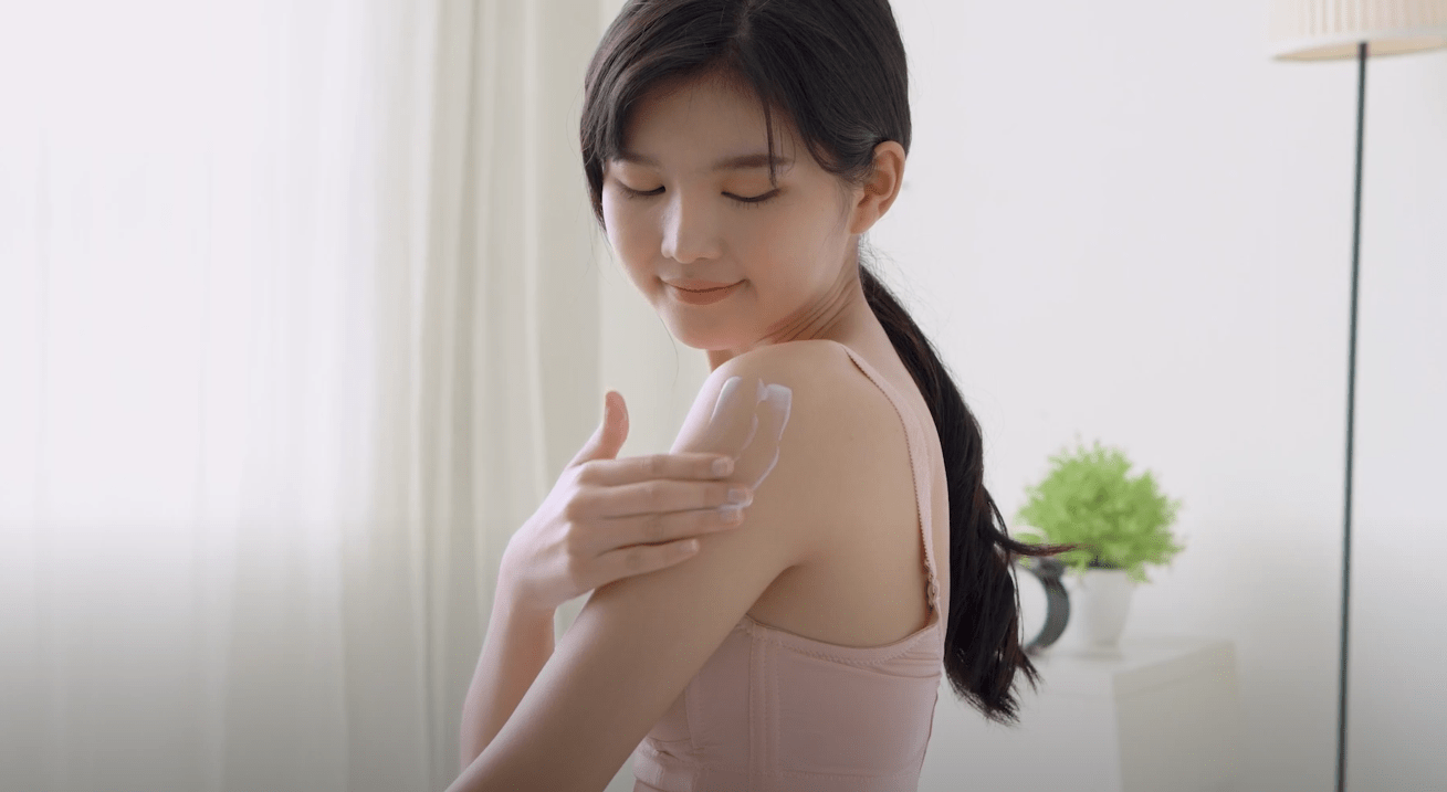 Applying cooling aloe vera gel to sunburned skin for relief