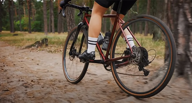 Cyclist doing a pre-ride warm-up stretch for their legs