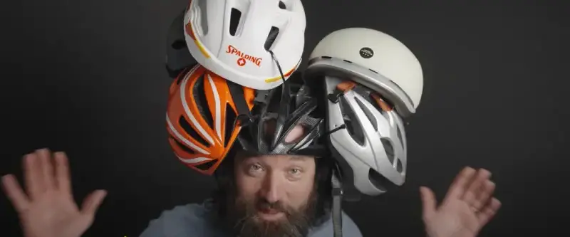 Cyclist with shaved head riding on a sunny road