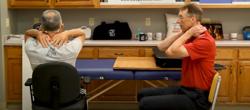 Man performing a chin tuck exercise to relieve stiffness